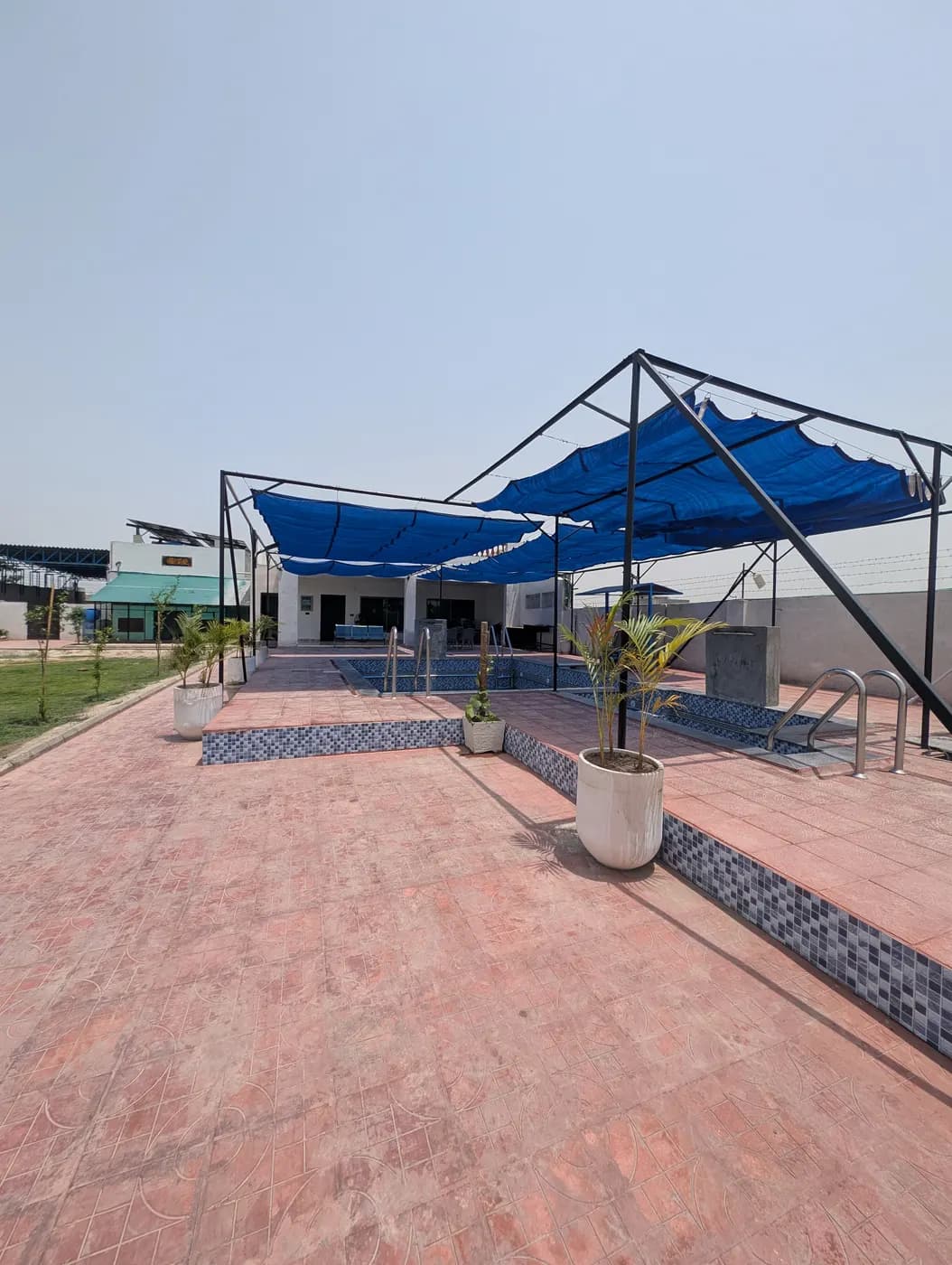 Kosam Farms terrace, pool, and lawn wide view