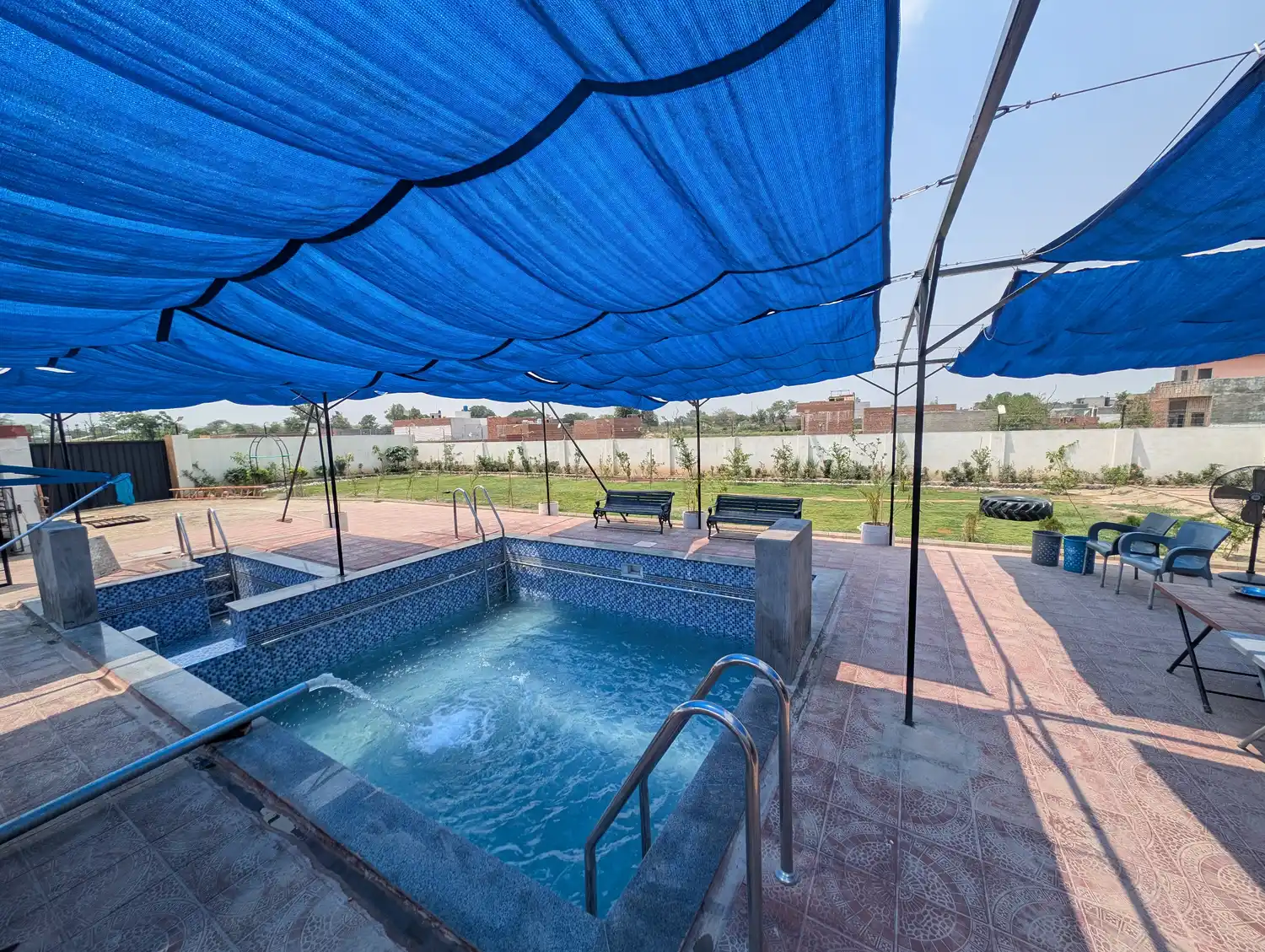 Kosam Farms pool with water feature and poolside benches